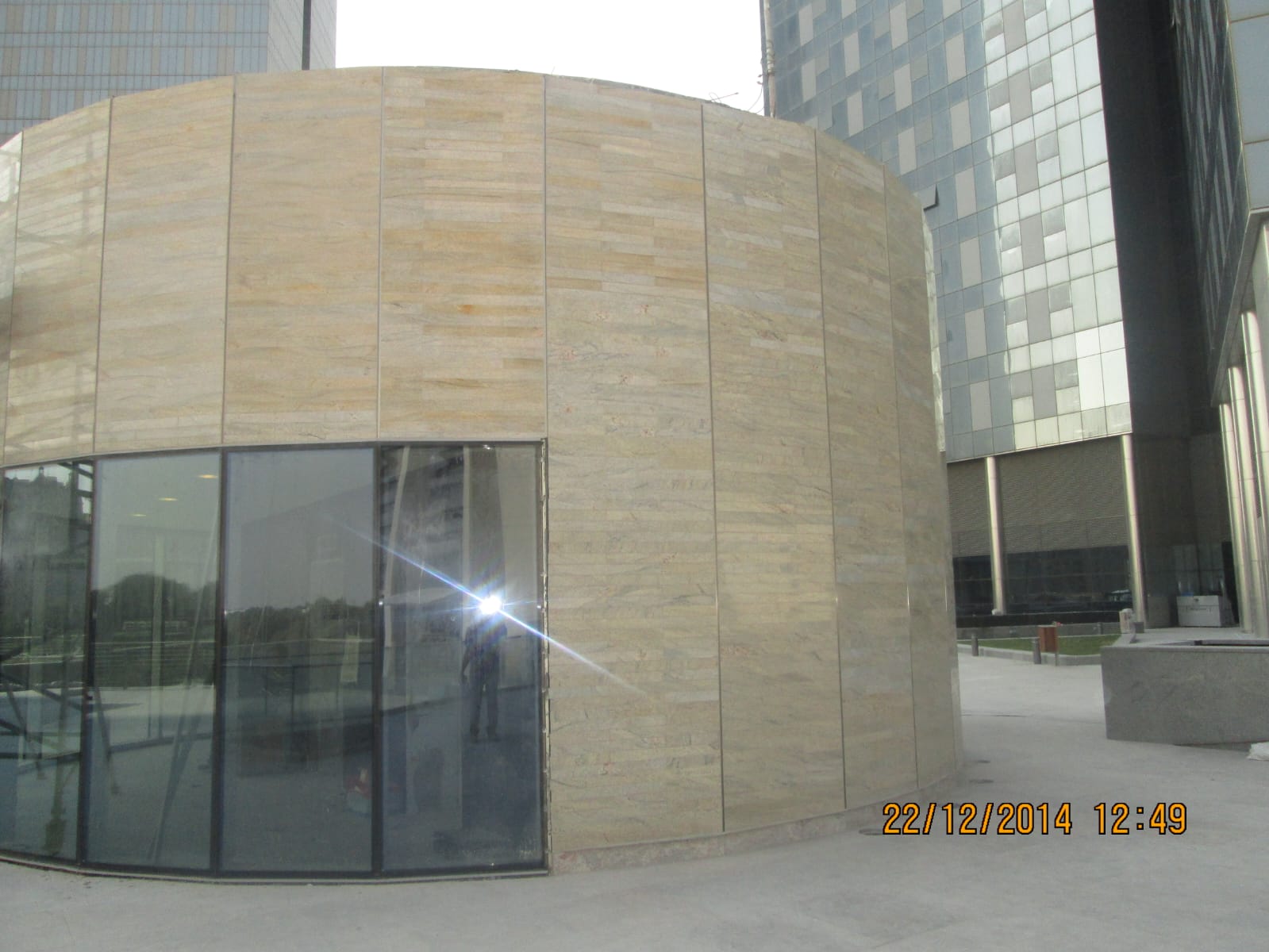 Curved commercial building facade clad in dry-jointed travertine panels