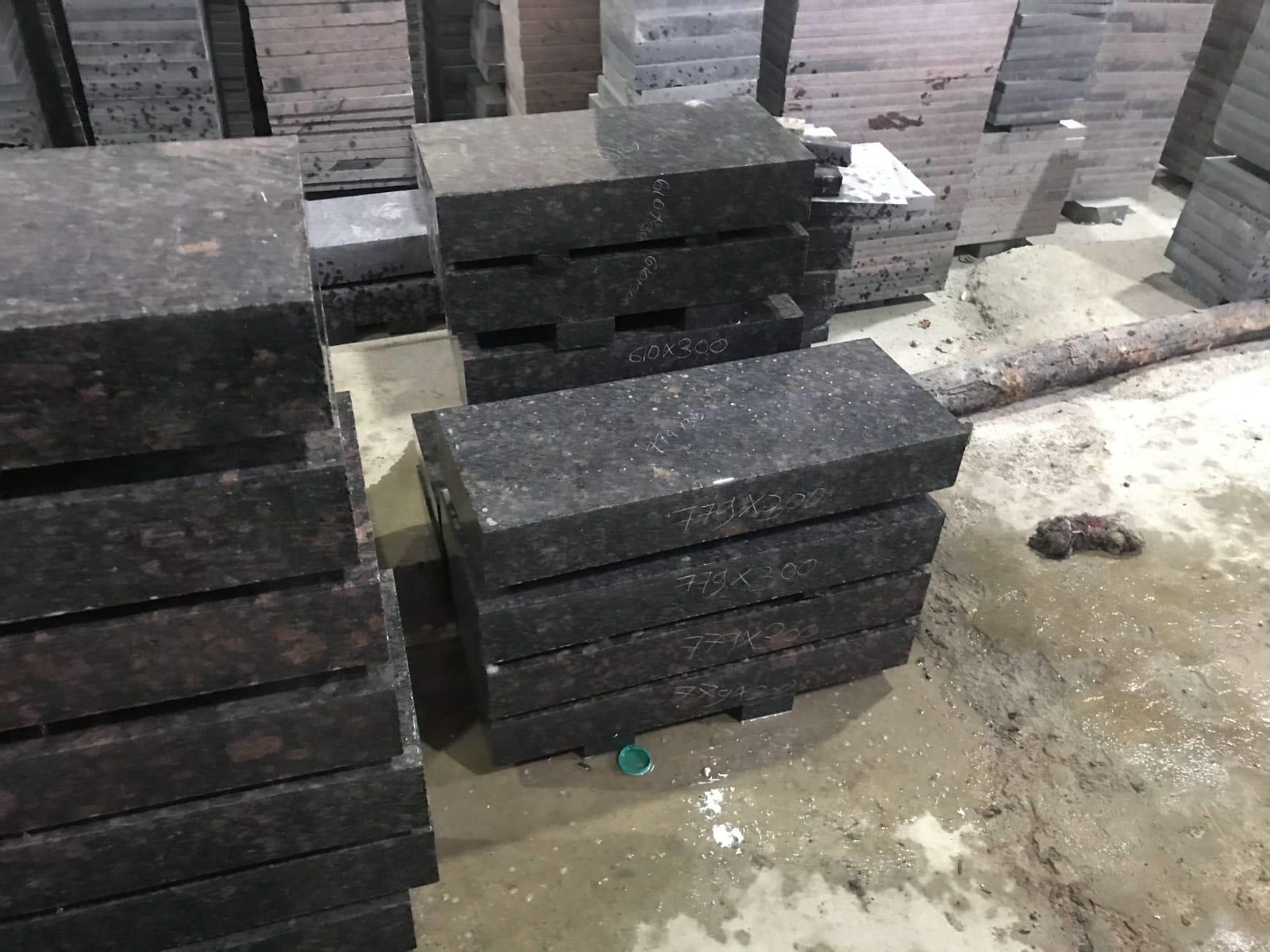Cut-to-size granite components marked with exact dimensions on the factory floor