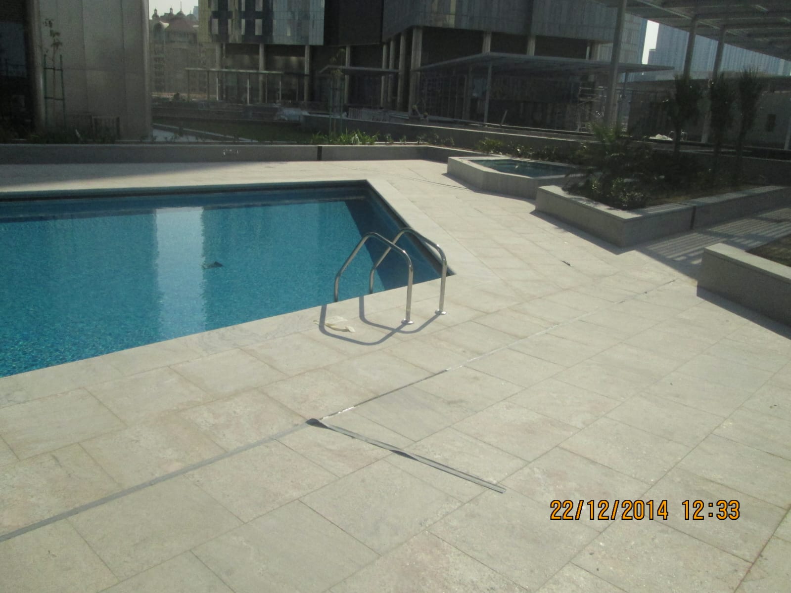 Rooftop swimming pool with travertine deck and coping at a hospitality development