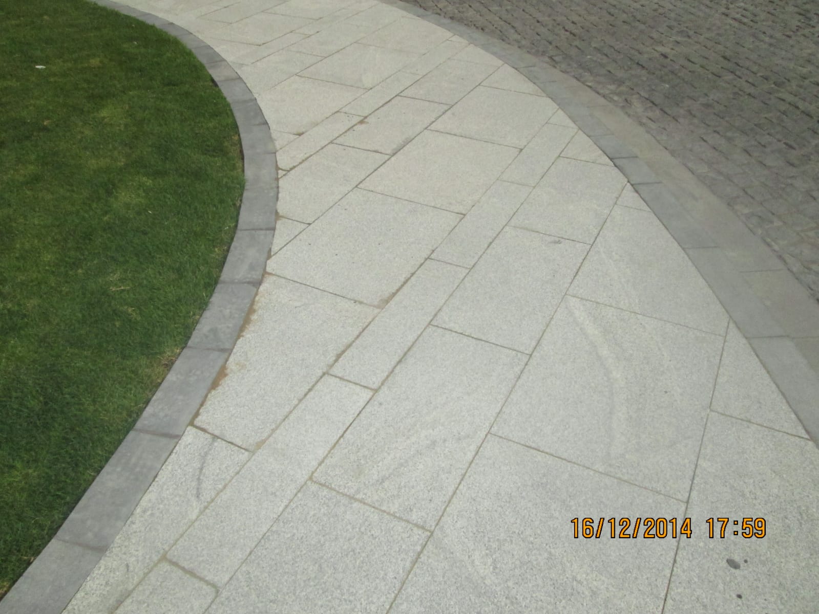 Granite landscape paving path with dark border edging beside a lawn